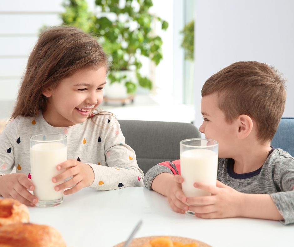 two kids drinking milk